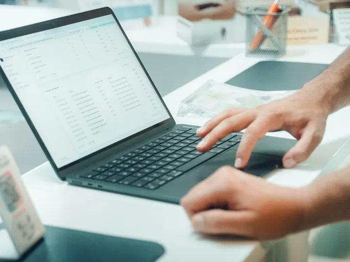 Nahaufnahme: Hände am Laptop bei der gemeinsamen Arbeit an der Webseite